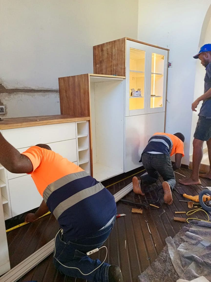 Tech1 Wood Works team fitting custom cabinets on site in Accra